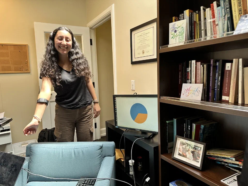 A participant wears a heart-rate sensor while a nearby monitor displays the live readings as a chart.
