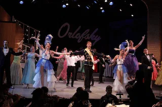 A large costumed ensemble dances across the stage beneath the word Orlofsky.