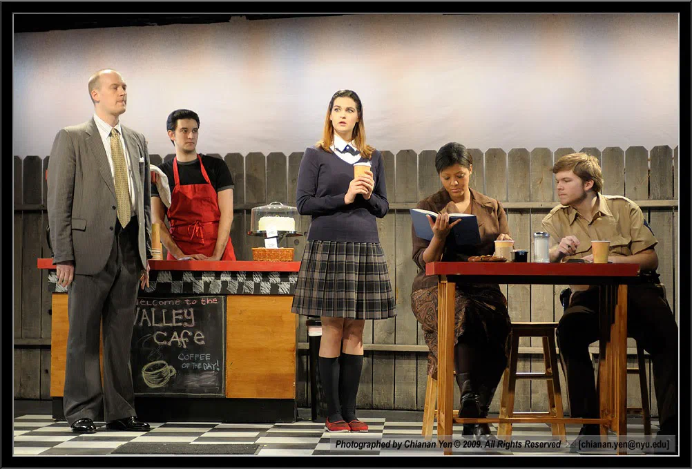 An ensemble performs around tables and a cafe counter.
